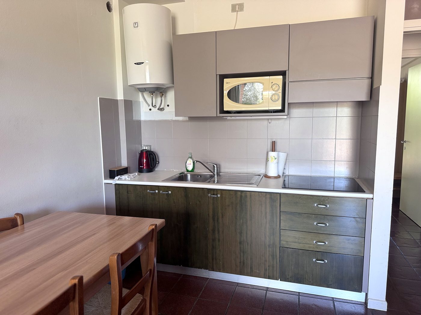 La cucina: piano a induzione, forno a microonde e lavello