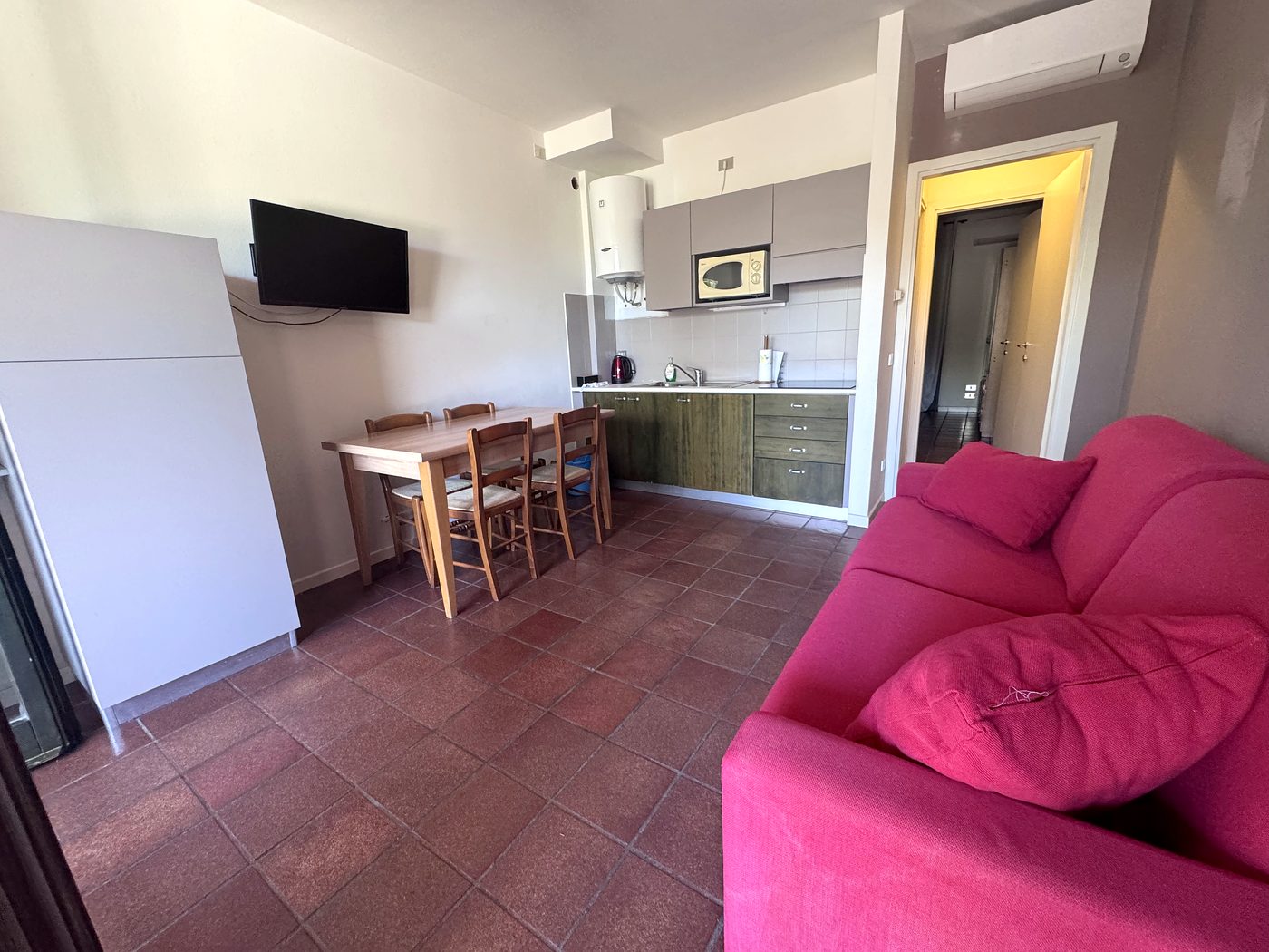 Il soggiorno con la cucina, il tavolo da pranzo e il divano letto