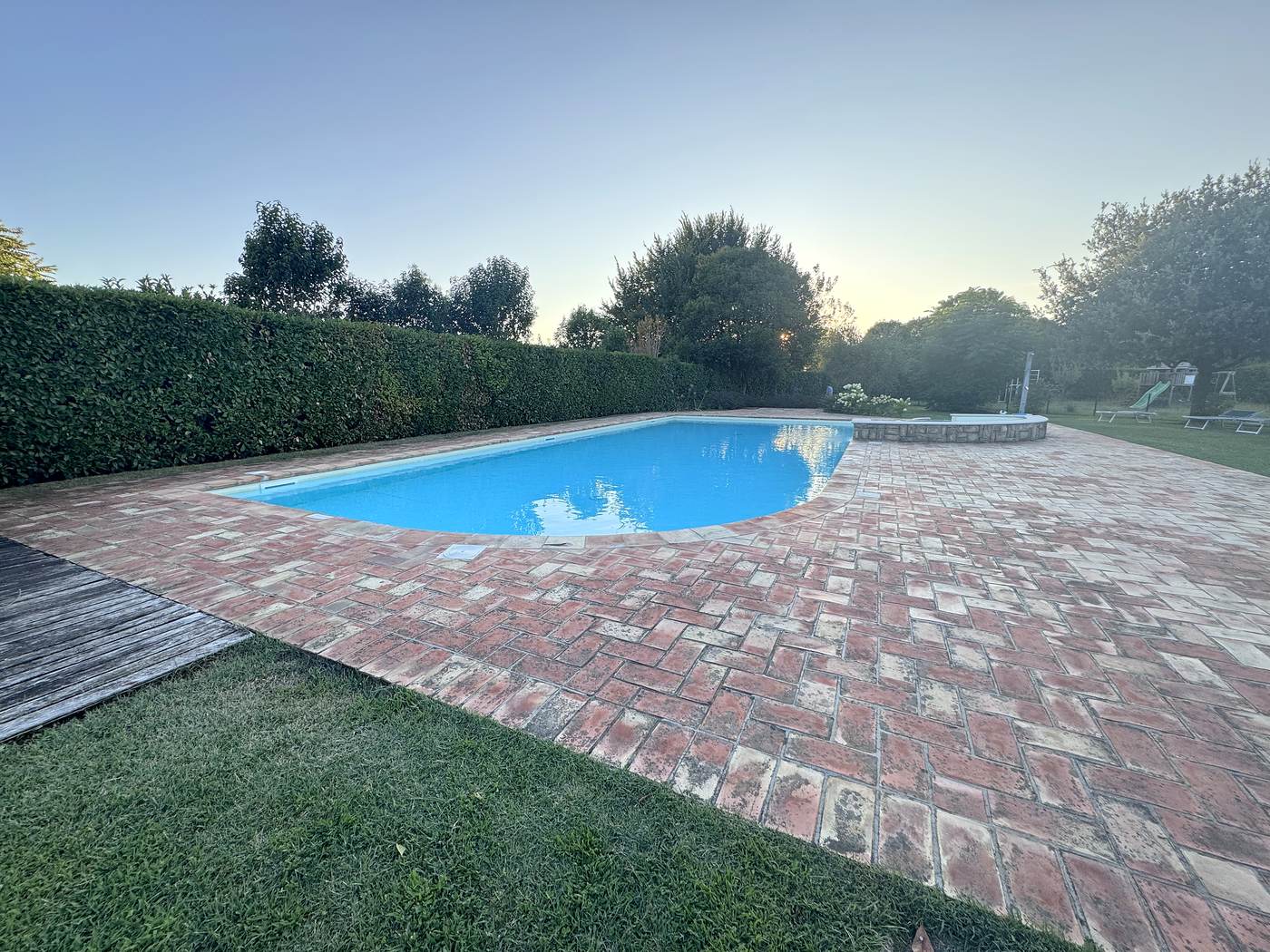 La piscina condominiale di giorno, con il prato intorno