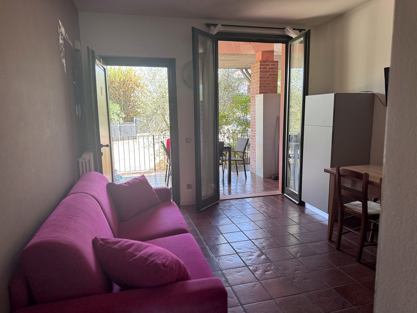 Il soggiorno con il divano letto e la porta-finestra aperta sul terrazzo
